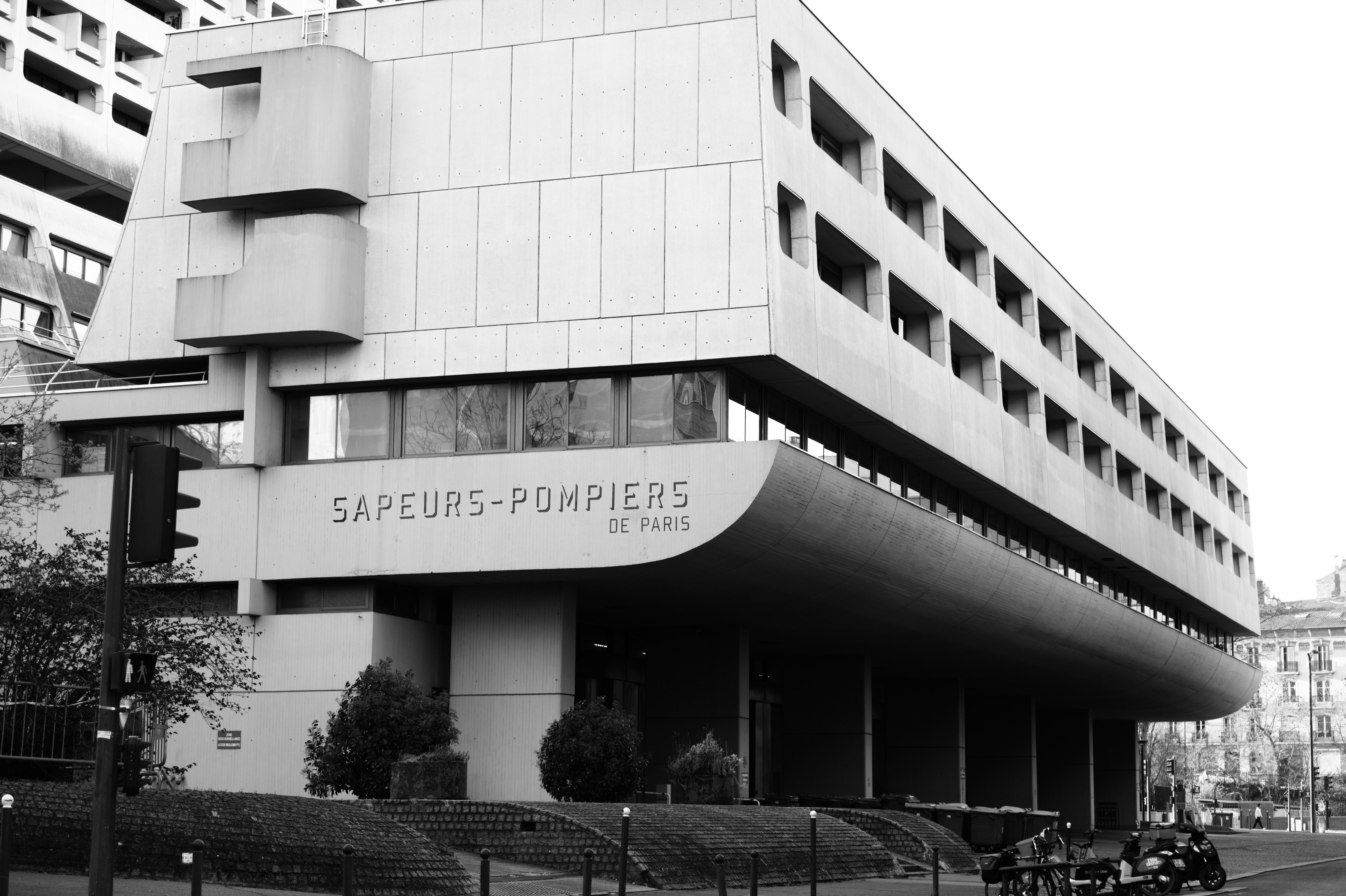 Fire station cantilevered mass with curved Sapeurs-Pompiers signage band