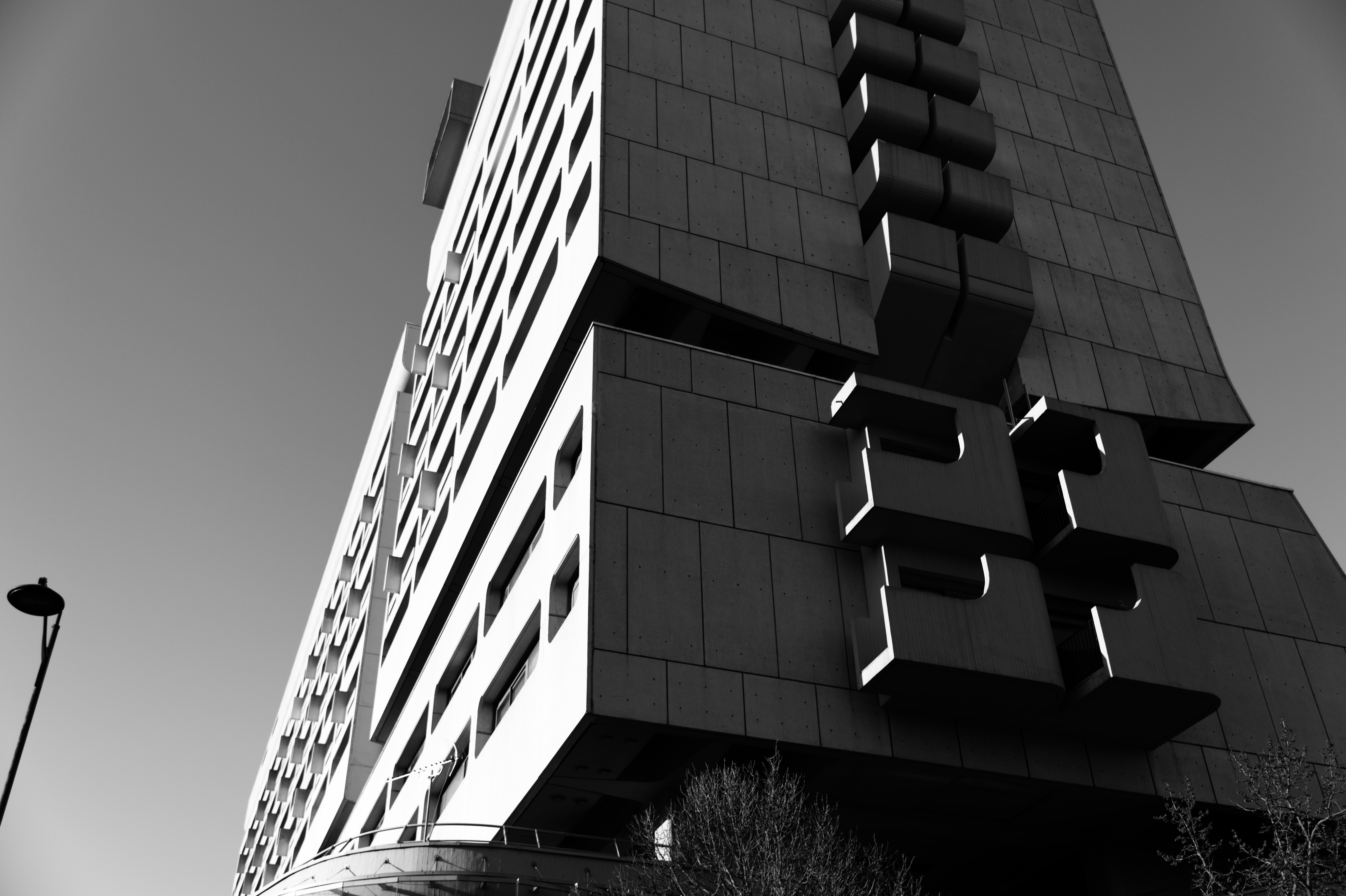 Stepped cantilevered balconies seen from below against clear sky