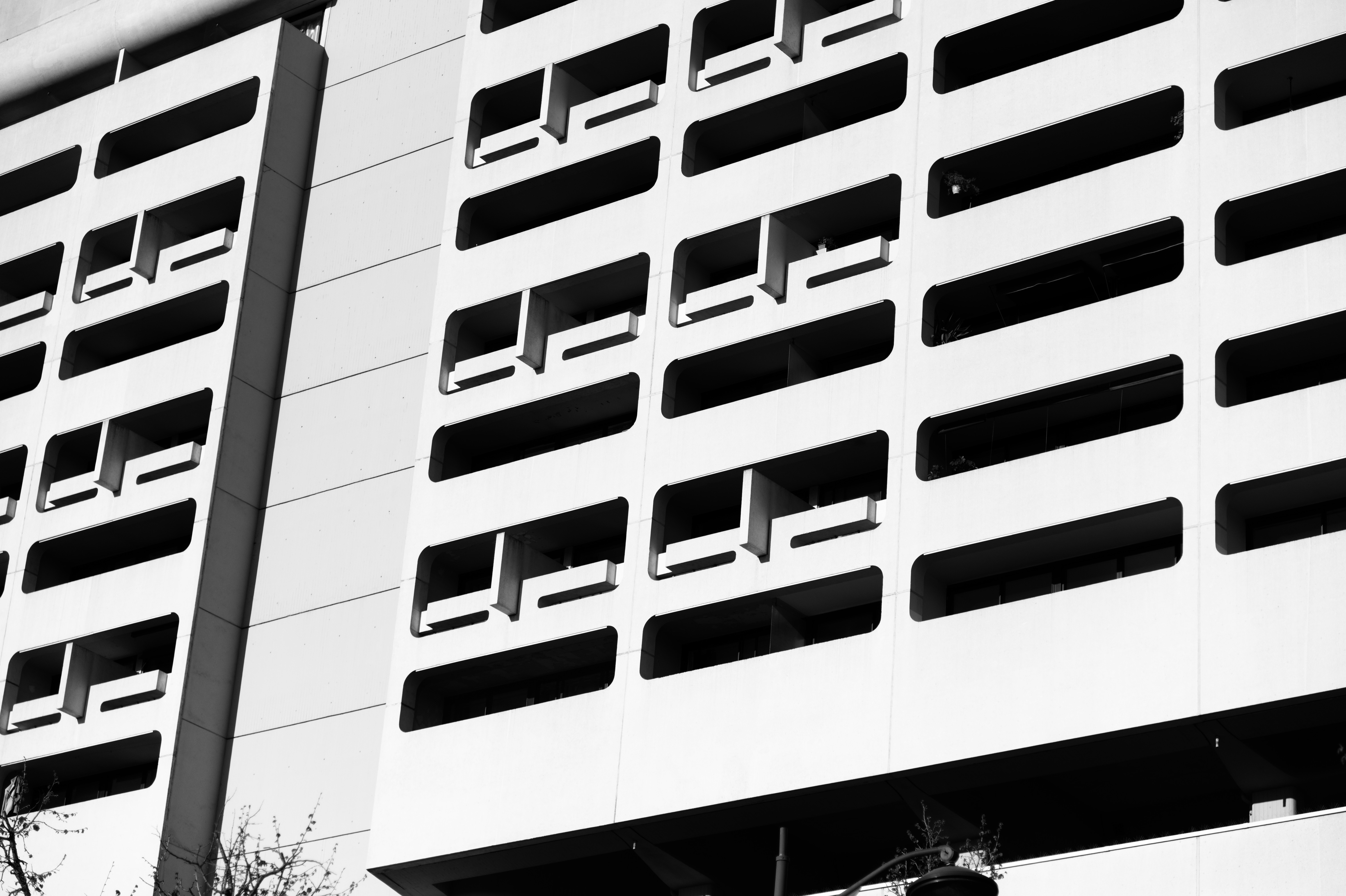 Geometric grid of recessed windows and projecting balconies