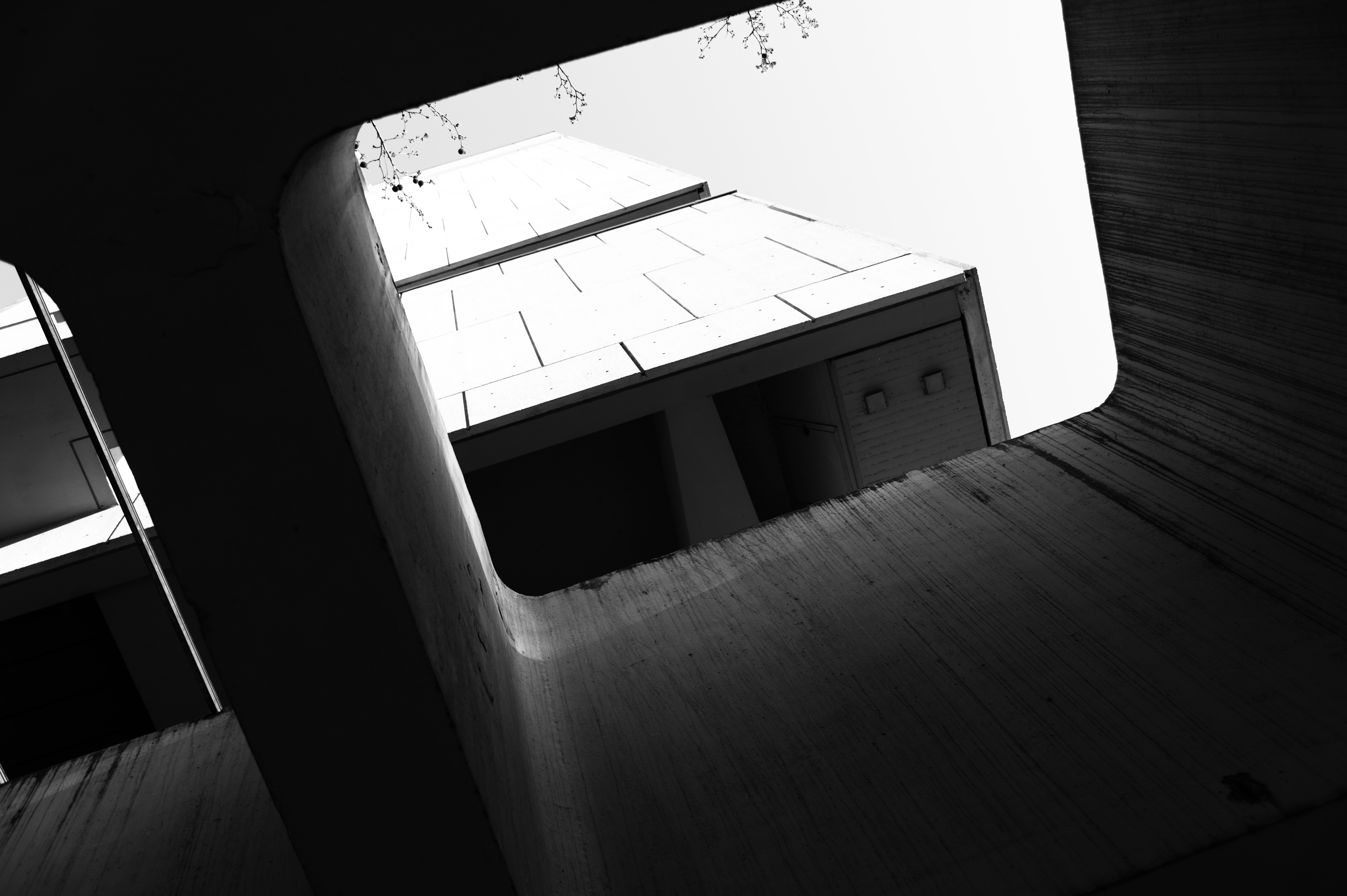 Curved raw concrete walls framing a geometric void